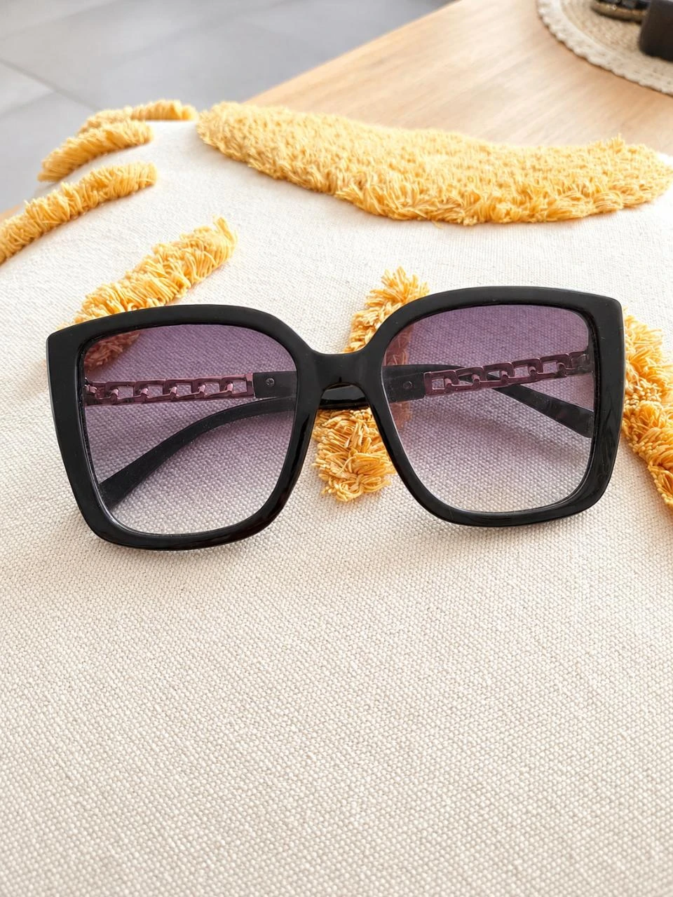 Lunettes de soleil noires à branches dorées oversize